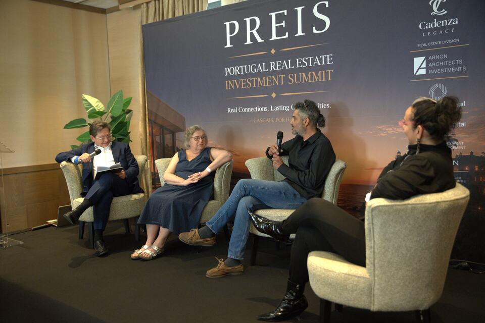 Four speakers seated onstage during a PREIS panel discussion