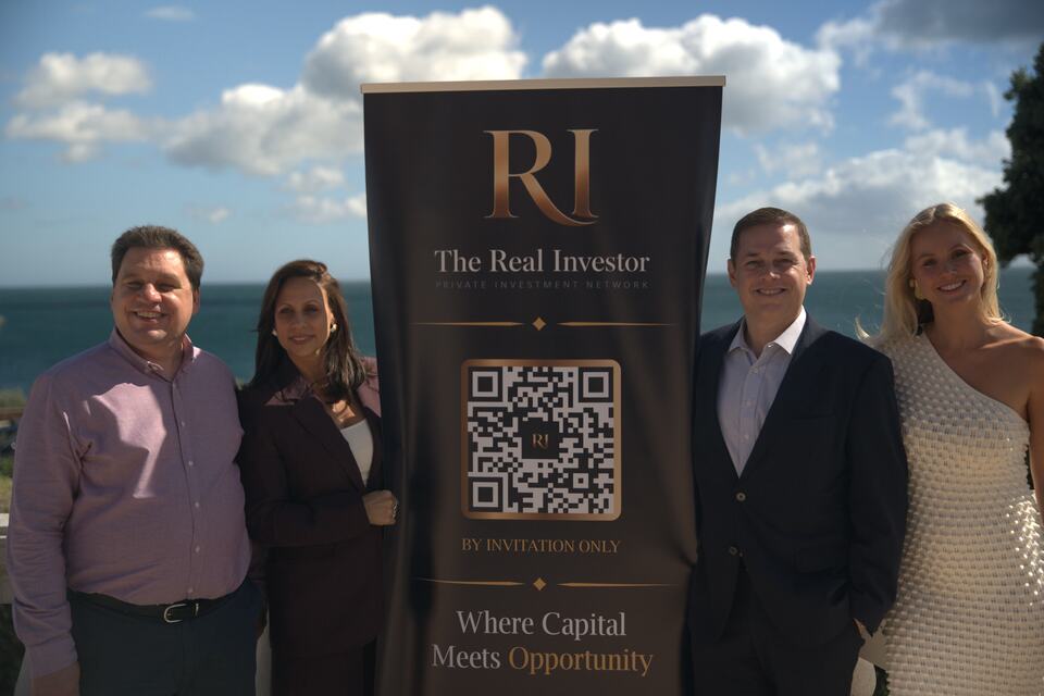 Four guests posing beside The Real Investor launch banner