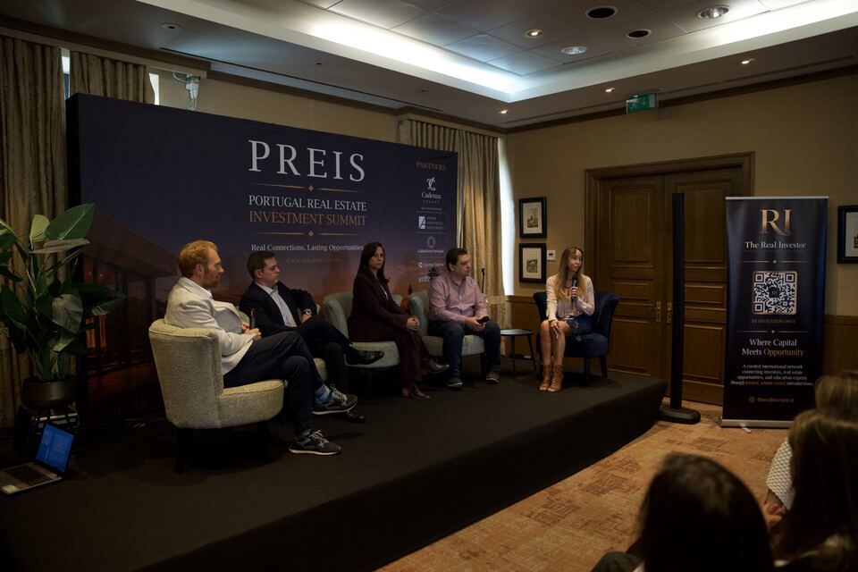 Five speakers seated on stage during a PREIS panel discussion